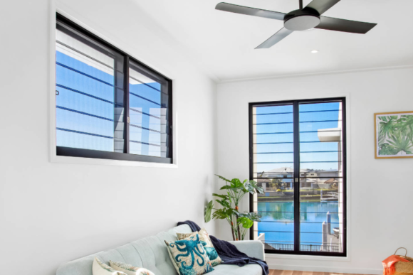 Aluminium glass louvre windows with black frames in coastal living room